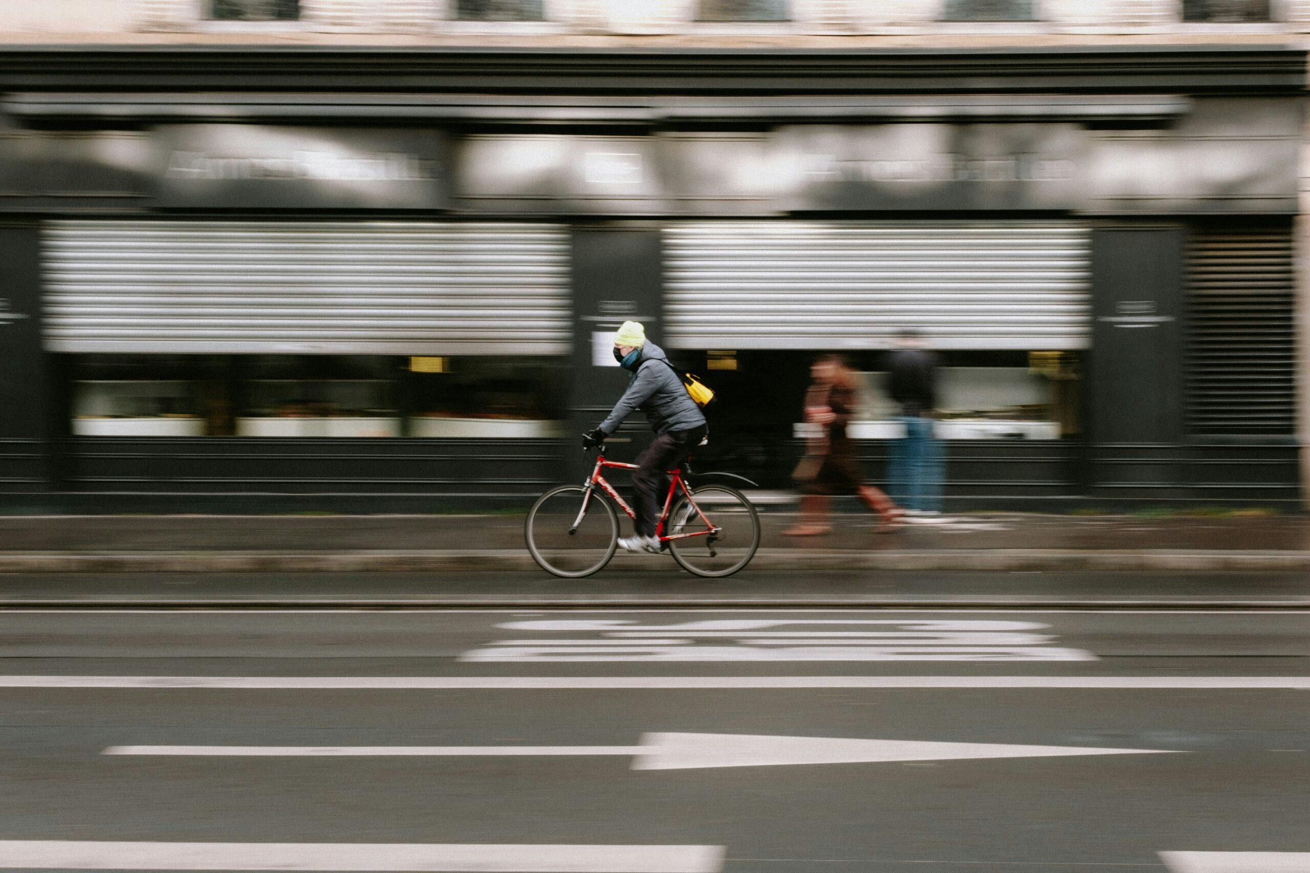Cyclist riding through city street with motion blur, representing bicycle accident or urban traffic scene